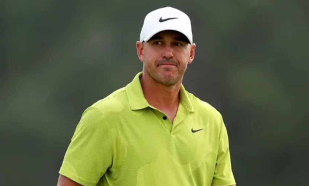 Brooks Koepka wearing a white cap and lime-green Nike polo shirt on a golf course.