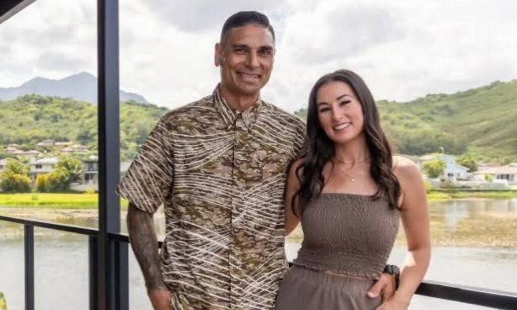 Tristyn Kalama and her husband Kamohai Kalama smiling together on a balcony overlooking a scenic Hawaiian landscape.